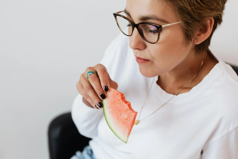 a woman is eating a slice of watermelon, by Julia Pishtar, trending on pexels, wearing reading glasses, wearing a light shirt, deep in thought, profile image