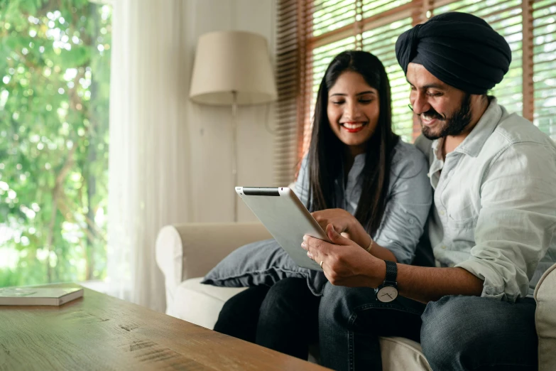 a man and woman sitting on a couch looking at a tablet, pexels contest winner, indian, south east asian with long, avatar image, college