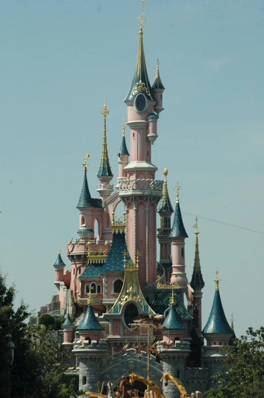 a castle sitting on top of a lush green field, inspired by disney, rococo, head and shoulder shot, zoomed, carousel, wikipedia