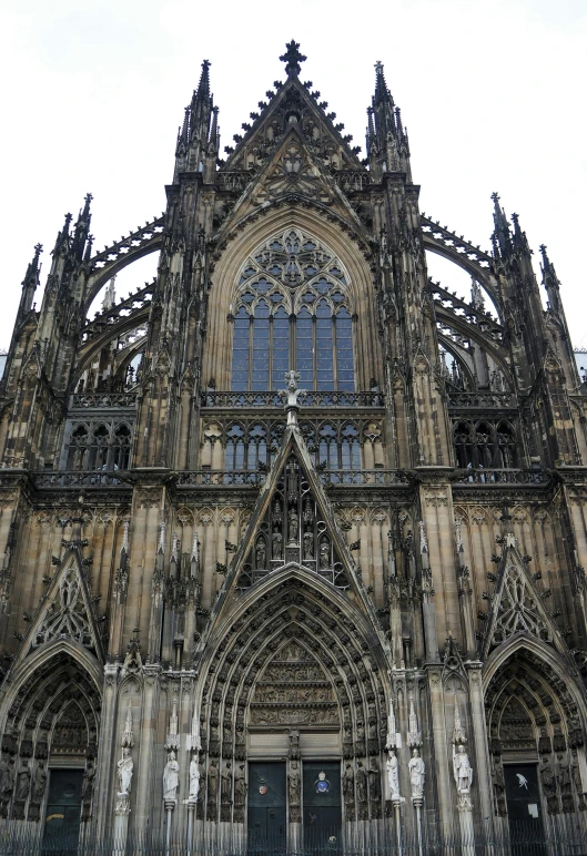 a group of people standing in front of a cathedral, wrought iron architecture, up close, qwek dom, stern