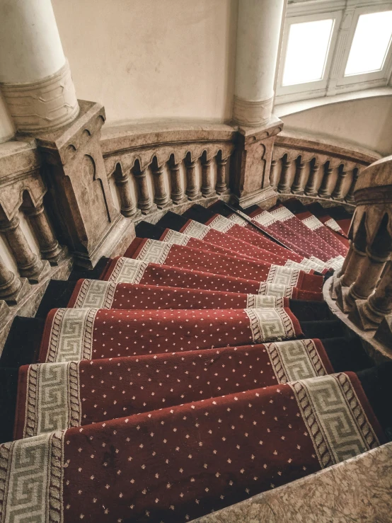 a red and white carpeted staircase next to a window, inspired by Mihály Munkácsy, unsplash contest winner, baroque, high - angle view, located in a castle, alessio albi, patterned