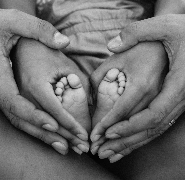 a woman holding her hands in the shape of a heart, a black and white photo, by Matt Stewart, tiny feet, 3 5 year brazilian mother, ❤🔥🍄🌪, human babies