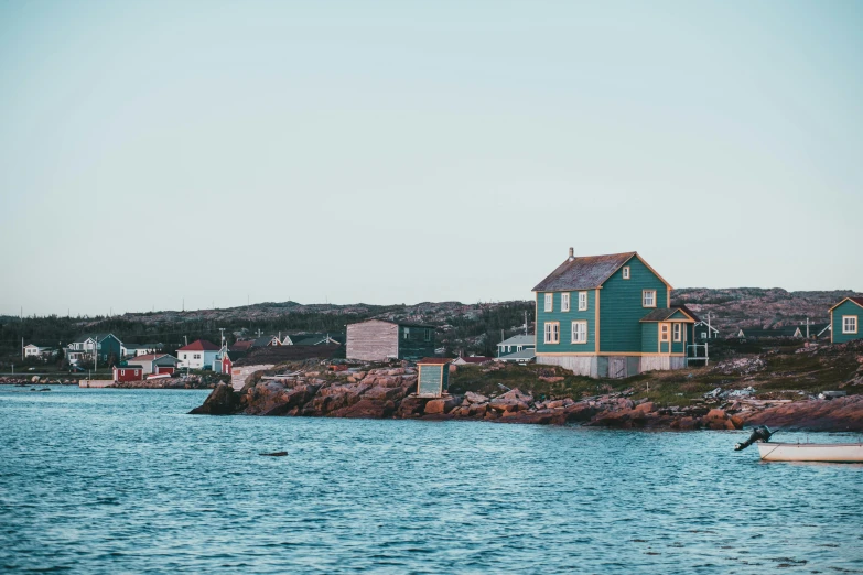 a small boat sitting on top of a body of water, a photo, inspired by Wilhelm Marstrand, pexels contest winner, happening, rustic stone cabin in horizon, colorful houses, moody : : wes anderson, harbour