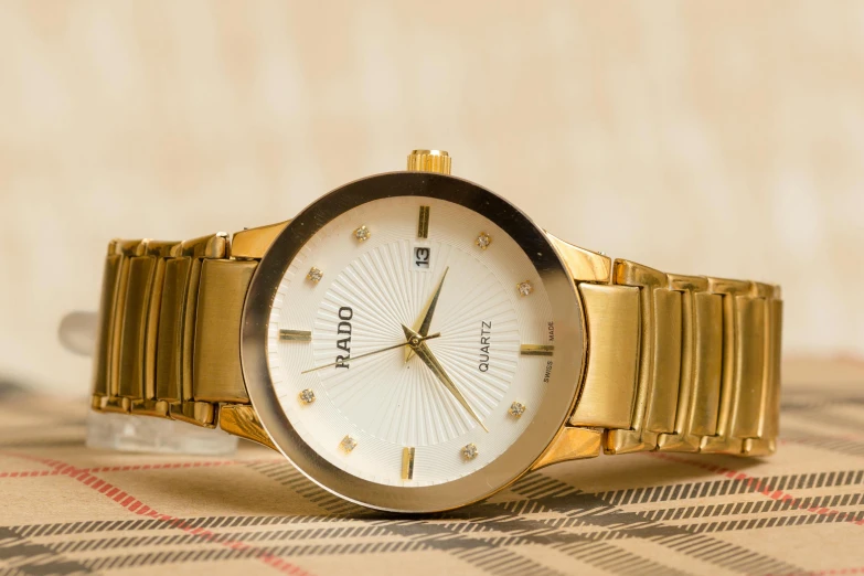 a close up of a watch on a table, an album cover, pexels contest winner, gold and white, harold newton, ratio, full face view