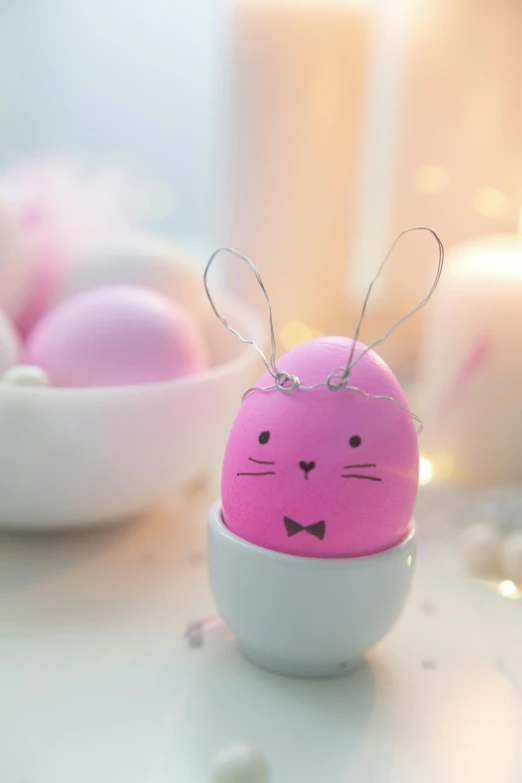 a pink bunny egg sitting on top of a table, decorations, looking towards camera, close up photograph, cosy