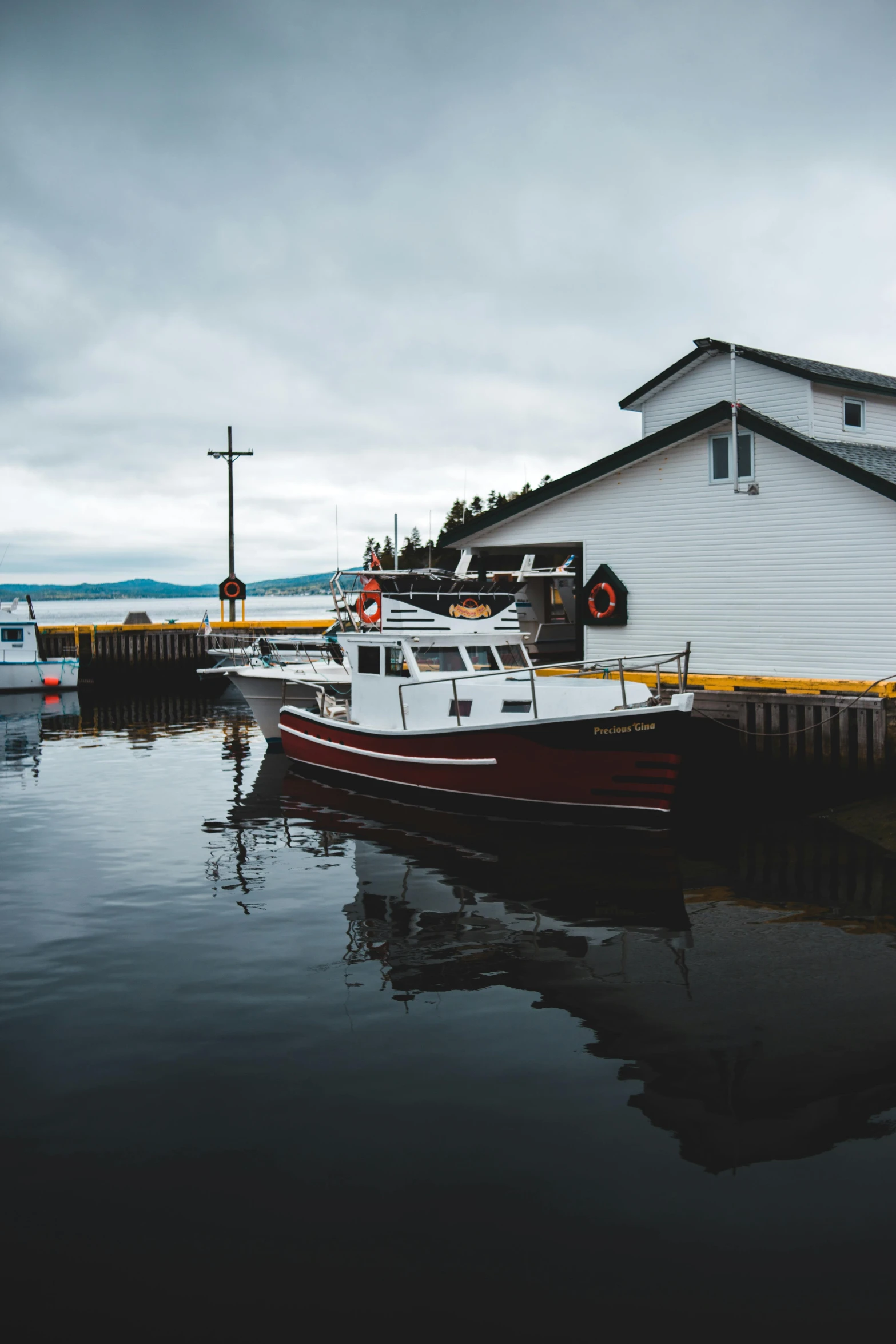 a boat that is sitting in the water, by Robert Storm Petersen, pexels contest winner, small buildings, docked at harbor, in dunwall, noelle stevenson