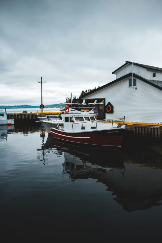 a boat that is sitting in the water, by Robert Storm Petersen, pexels contest winner, small buildings, docked at harbor, in dunwall, noelle stevenson