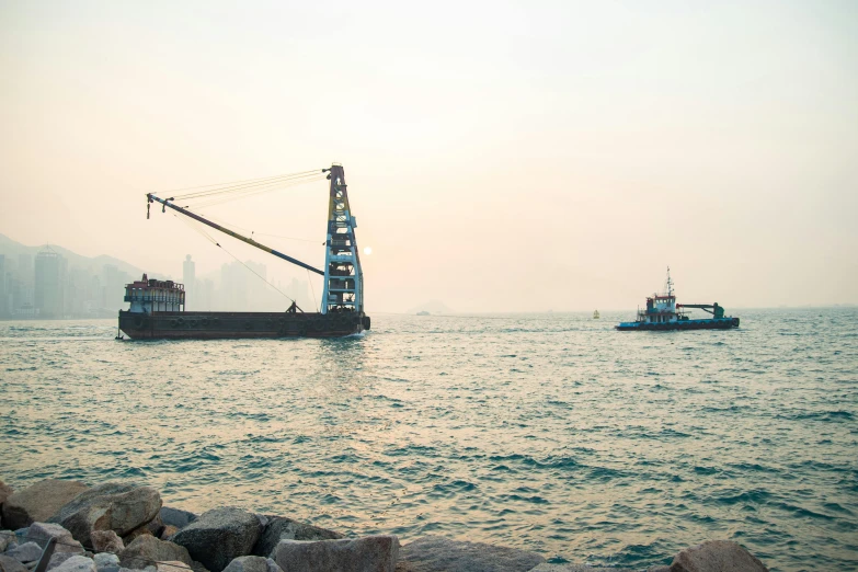 a couple of boats that are in the water, inspired by Zhang Kechun, unsplash, happening, construction site, viewed from the harbor, 1980s photo