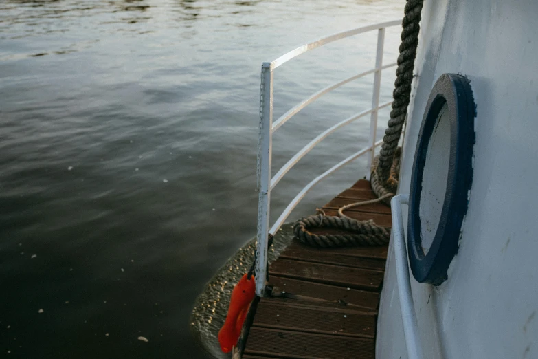 a close up of a boat on a body of water, by Attila Meszlenyi, pexels contest winner, railing, side view, a portal to the depths, bucklebury ferry