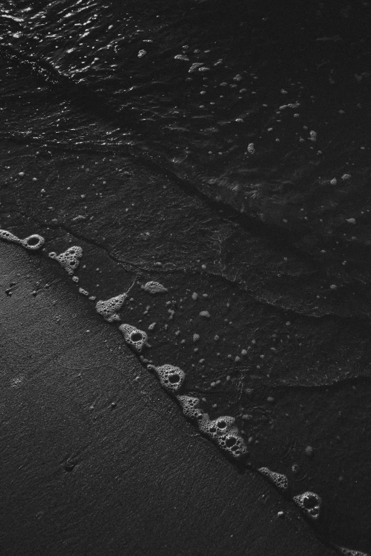 a black and white photo of a surfboard on the beach, a black and white photo, unsplash, minimalism, detailed droplets, erosion, night, ( ( abstract ) )