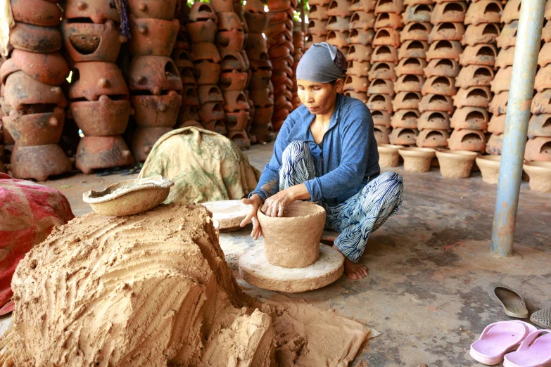 a woman sitting in front of a pile of clay pots, blending, nivanh chanthara, avatar image, small manufacture