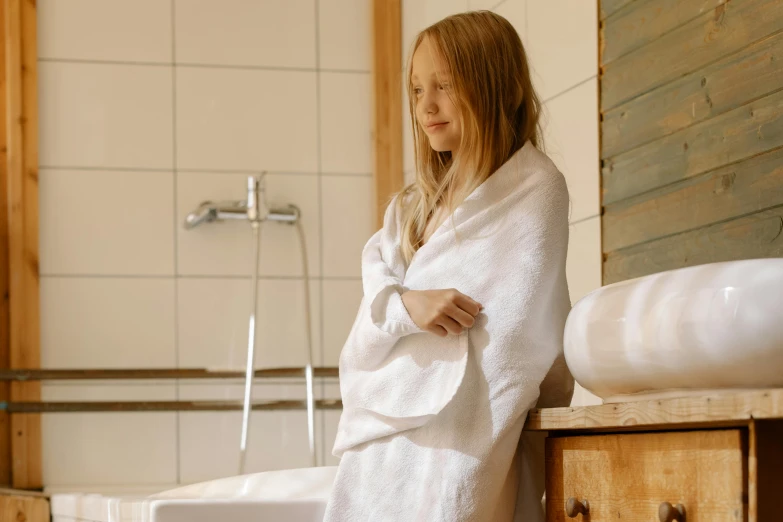 a woman wrapped in a white towel in a bathroom, pexels contest winner, tiny girl looking on, satisfied pose, children's, sauna