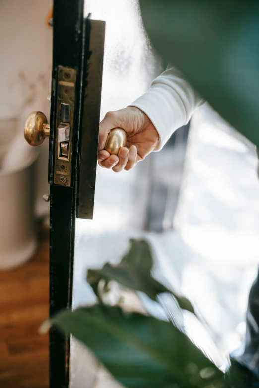 a close up of a person opening a door, by Julia Pishtar, home setting, shiny gold, premium, mid riff