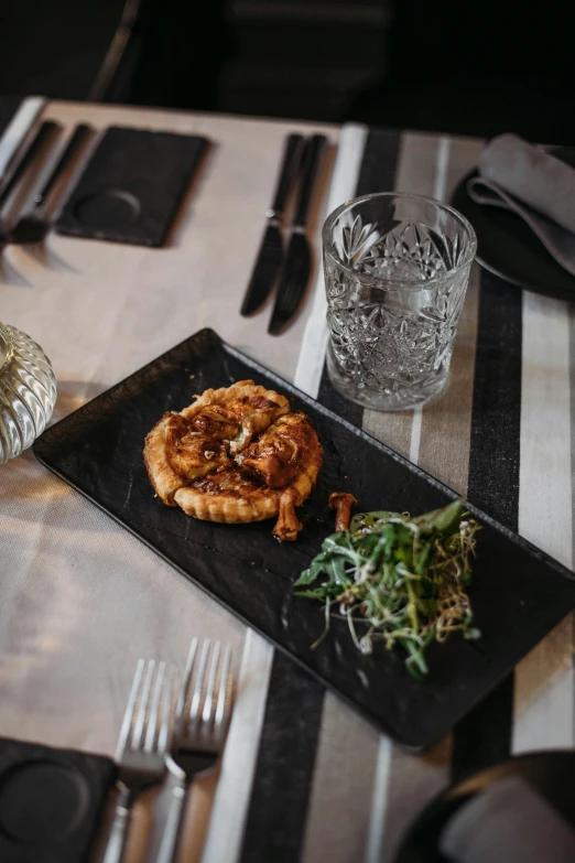 a close up of a plate of food on a table, inspired by Richmond Barthé, unsplash, renaissance, black, leftover meat pie, square, luxurious environment