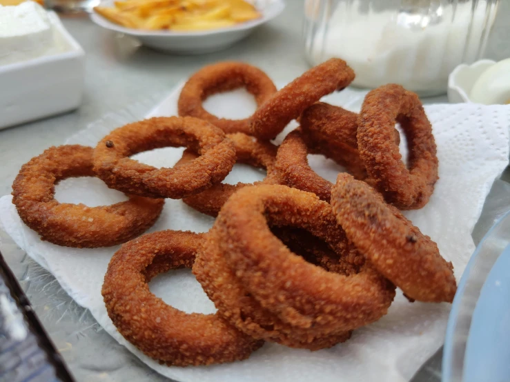 a pile of onion rings sitting on top of a table, by Tom Wänerstrand, pexels, hurufiyya, square, costa blanca, frying nails, 🦩🪐🐞👩🏻🦳