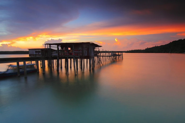 a boat sitting on top of a body of water, pexels contest winner, hurufiyya, houses on stilts, sunsetting color, malaysian, grey