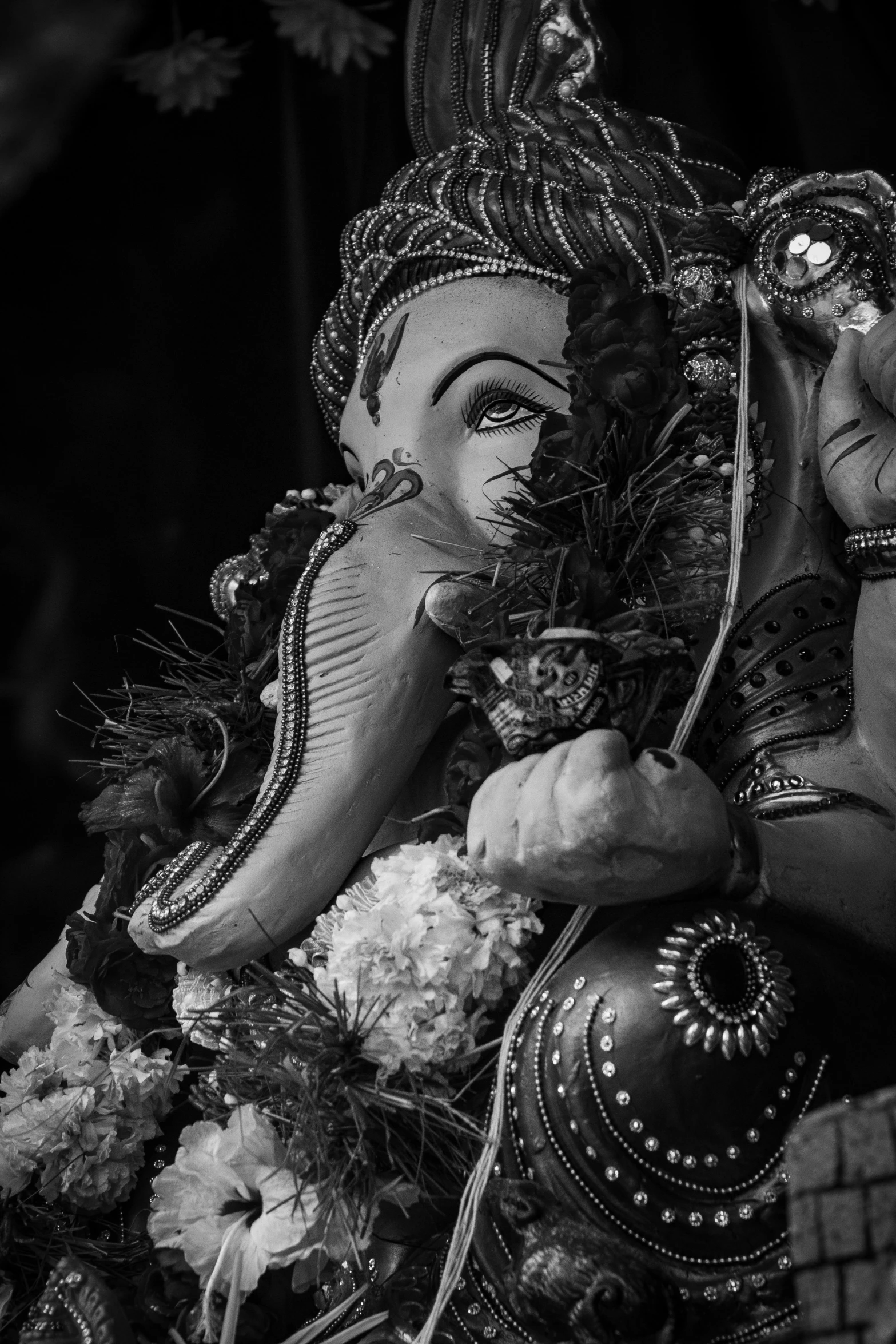 a black and white photo of a statue of an elephant, a black and white photo, unsplash contest winner, samikshavad, ganesha, on his right hand, ornately dressed, flowers