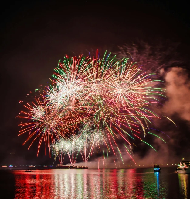 fireworks in the sky over a body of water, by Ejnar Nielsen, pexels contest winner, hurufiyya, vibrant red and green colours, historical photo, a wooden, notan