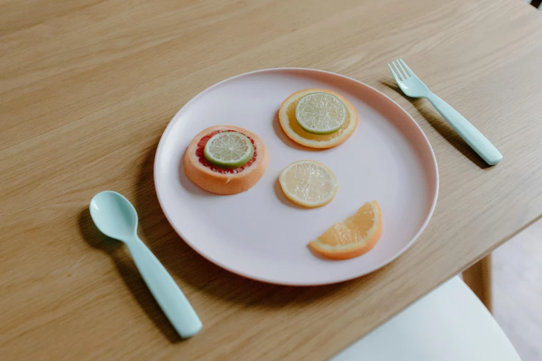 a white plate topped with slices of fruit, trending on pexels, minimalism, cute smiling face, spoon placed, pastell colours, rendered in arnold