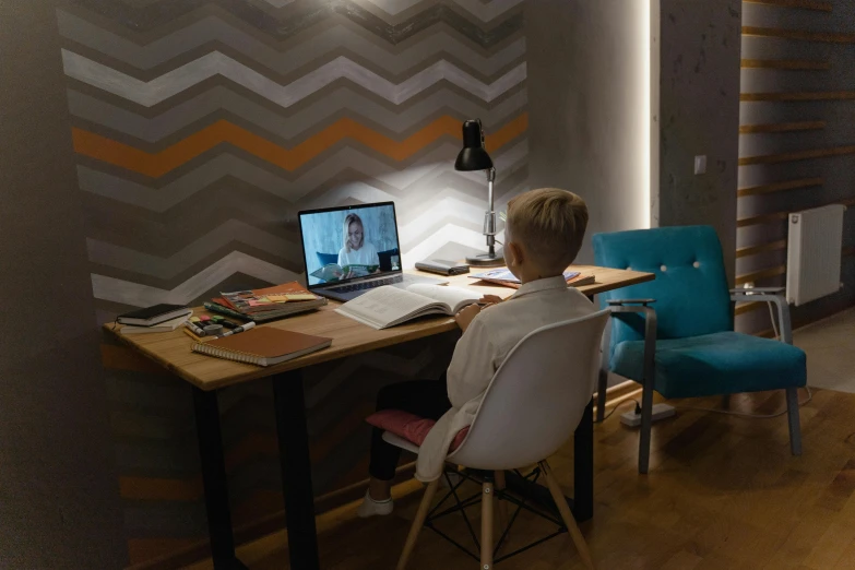 a boy sitting at a desk in front of a laptop computer, by Julia Pishtar, pexels contest winner, video art, in a meeting room, room lighting, kramskoi 4 k, wide high angle view