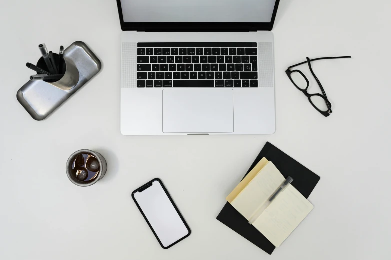 a laptop computer sitting on top of a white desk, pexels, 9 9 designs, objects, multiple stories, top down photo