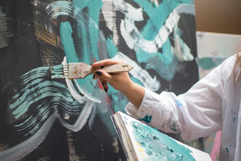 a woman is painting on a wall with a brush, an acrylic painting, by Julia Pishtar, pexels contest winner, action painting, palette knife and brush strokes, on canvas, symmetrical painting, academic painting