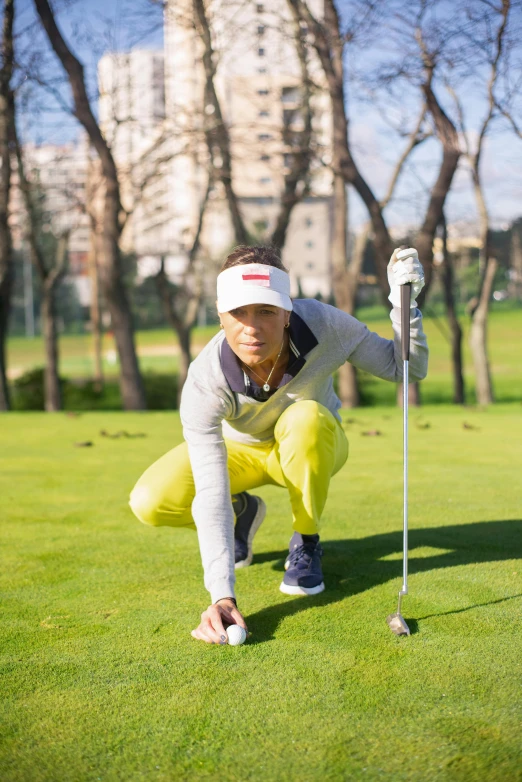 a man kneeling on top of a green field next to a golf ball, shin hanga, avatar image, sports clothing, grey, louise zhang