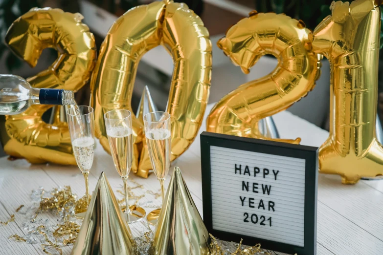 a table with balloons, champagne glasses and a sign that says happy new year 2021, trending on pexels, happening, gold clothes, 🚿🗝📝, 90s photo, profile image