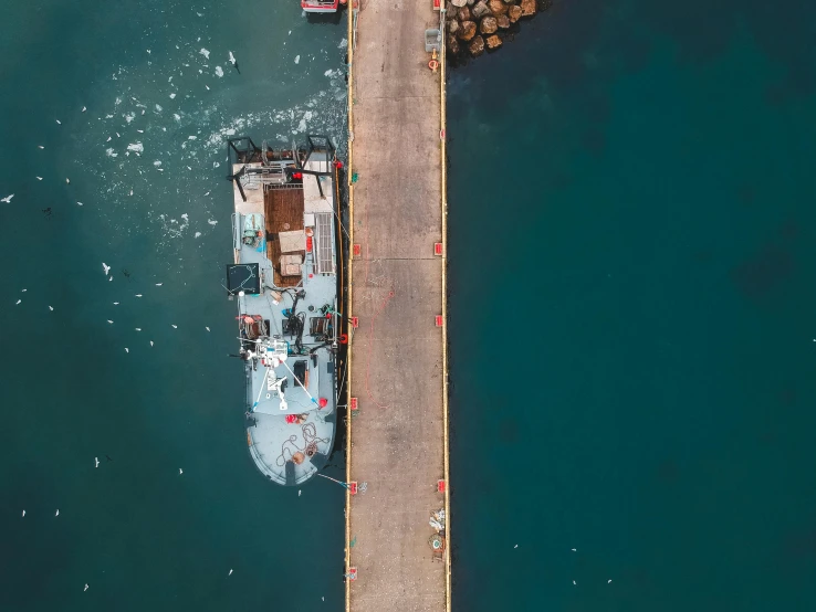 an aerial view of a boat docked at a pier, by Adam Marczyński, pexels contest winner, hurufiyya, utilitarian cargo ship, thumbnail, celebrating, near a jetty