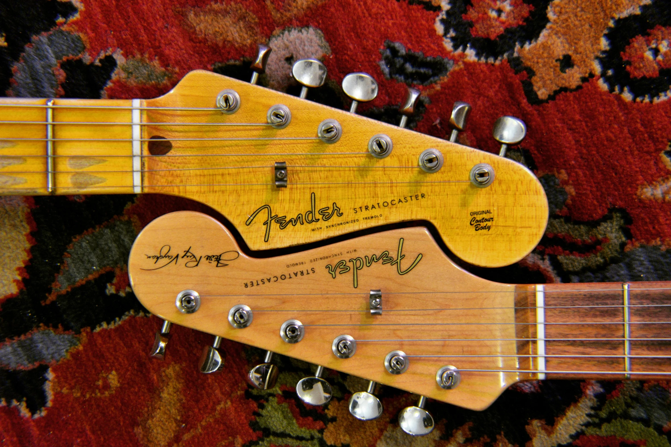 a close up of a guitar on a rug, holding electric guitars, back to back, fender stratocaster, viewed from below