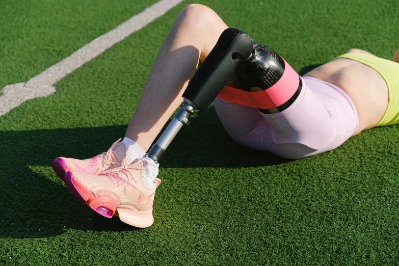 a woman laying on the ground with a broken leg, a digital rendering, unsplash, sports setting, prostheses, poppy, mechanised
