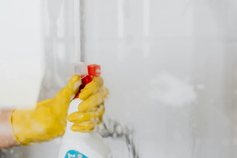 a person in yellow gloves holding a spray bottle, a cartoon, by Julia Pishtar, pexels, bleeding in the bath, covered in white flour, clean background, background image