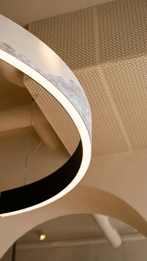 a clock hanging from the ceiling of a building, nadir lighting, curved body, high texture detail, ring lit