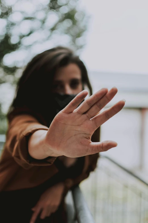 a woman holding her hand out of the window of a car, by Kristian Zahrtmann, pexels, hands shielding face, girl with brown hair, paul barson, scratched