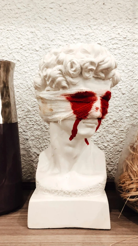 a couple of vases sitting on top of a wooden table, a statue, by Robbie Trevino, reddit, vanitas, red paint strip across eyes, covered in blood, jimin\'s grecian nose, halloween decorations