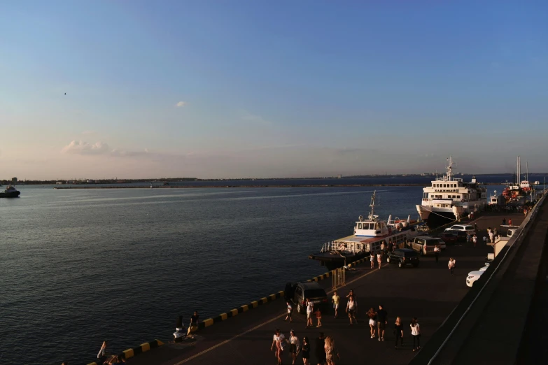 a group of people standing on top of a pier next to a body of water, ships, gigapixel photo, summer evening, hziulquoigmnzhah