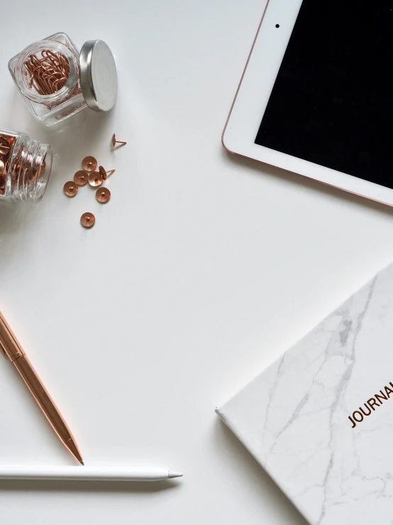 a tablet computer sitting on top of a white table, by Matija Jama, trending on unsplash, copper spiral hair decorations, luxury journal cover, high angle close up shot, white marble