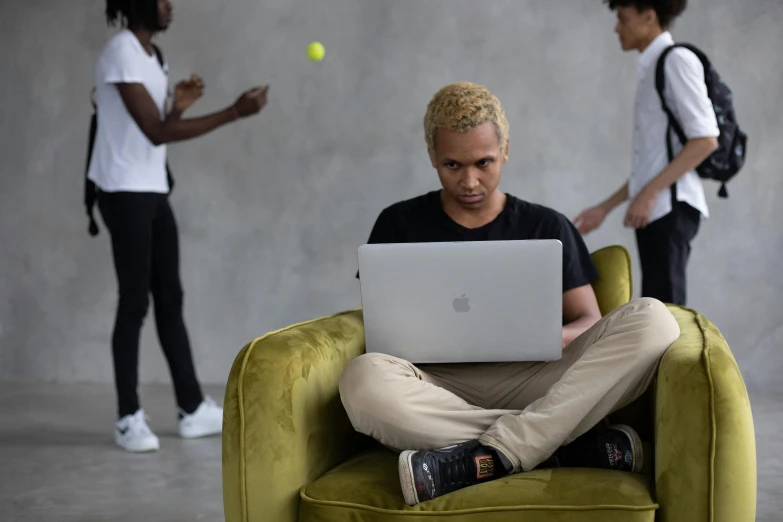 a man sitting in a chair with a laptop on his lap, pexels contest winner, short blonde afro, people watching around, 15081959 21121991 01012000 4k, with apple