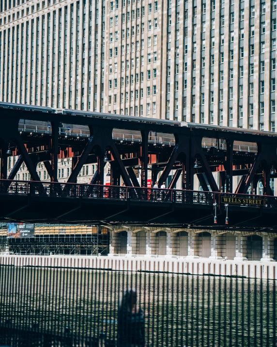 a train crossing a bridge over a river, a photo, by Robbie Trevino, pexels contest winner, modern chicago streets, 🚿🗝📝, buildings covered in black tar, gif