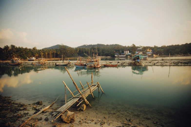 a group of boats sitting on top of a body of water, by Elsa Bleda, sumatraism, small port village, medium format. soft light, conde nast traveler photo