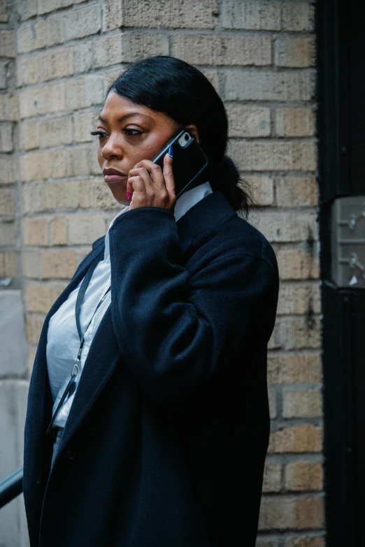 a woman in a black coat talking on a cell phone, by Emanuel Witz, trending on pexels, police officer, dark skinned, security agent, movie still