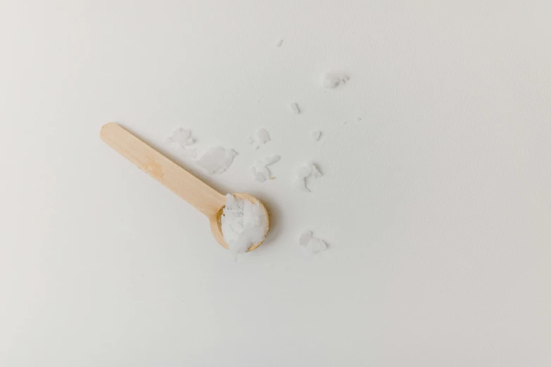 a wooden spoon sitting on top of a white surface, product image, salt effects, high quality product image”