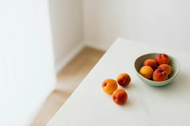 a bowl of peaches and a bowl of apricots on a table, inspired by William Berra, unsplash contest winner, white marble interior photograph, background image, full body image, minimal kitchen