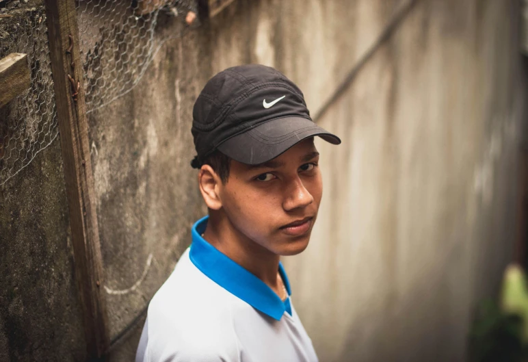 a close up of a person wearing a hat, black teenage boy, ronaldo luis nazario da lima, swoosh, low profile