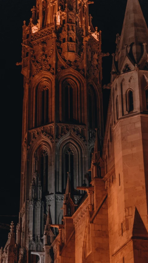 a very tall building with a clock on it's side, an album cover, by Tobias Stimmer, pexels contest winner, romanesque, night colors, alabaster gothic cathedral, exterior view, red and orange glow