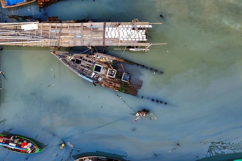 a group of boats floating on top of a body of water, a portrait, inspired by Filip Hodas, unsplash contest winner, hurufiyya, scrapyard, bird view, shipyard, abel tasman