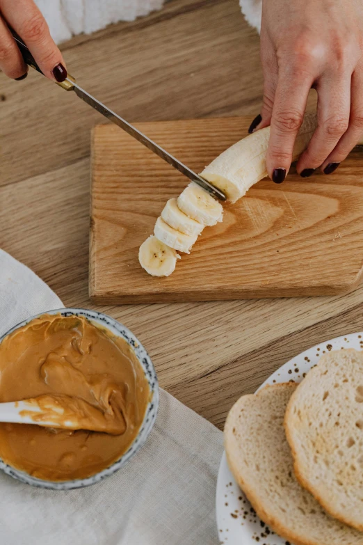 a person cutting a banana on a cutting board, inspired by Richmond Barthé, sandwich, caramel, humus, detailed product image