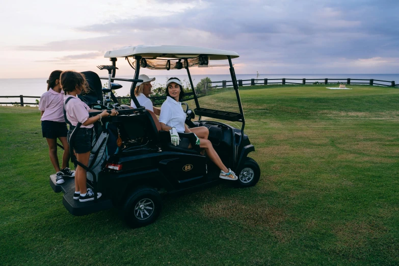 a group of people riding on the back of a golf cart, a portrait, unsplash, isabela moner, evening sun, sydney hanson, on the coast