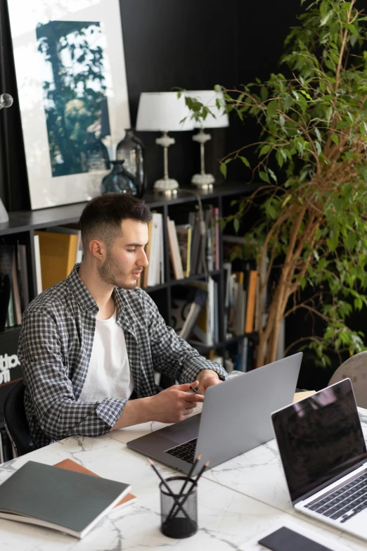 a man sitting at a table with two laptops, trending on pexels, arbeitsrat für kunst, 9 9 designs, profile picture, home office interior, casually dressed