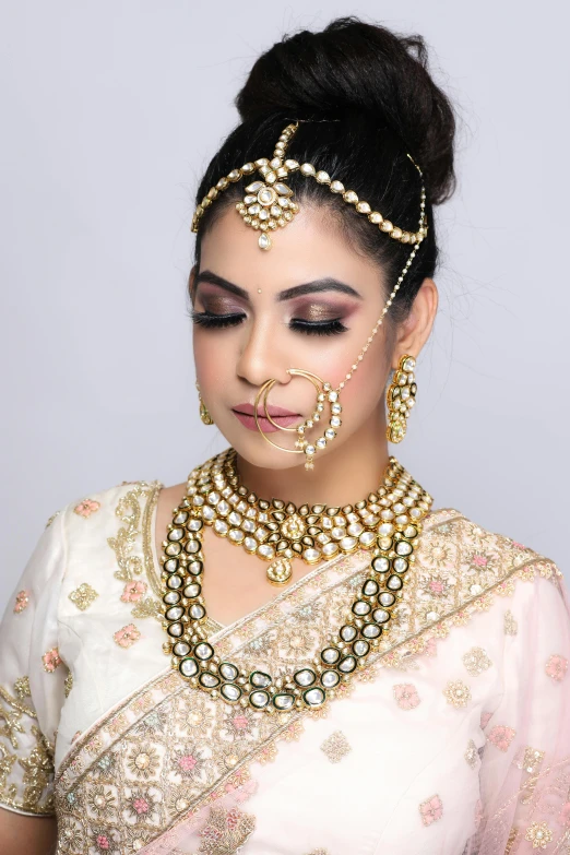 a woman in a white sari and gold jewelry, featured on instagram, professionally retouched, thumbnail, grayish, low - level view